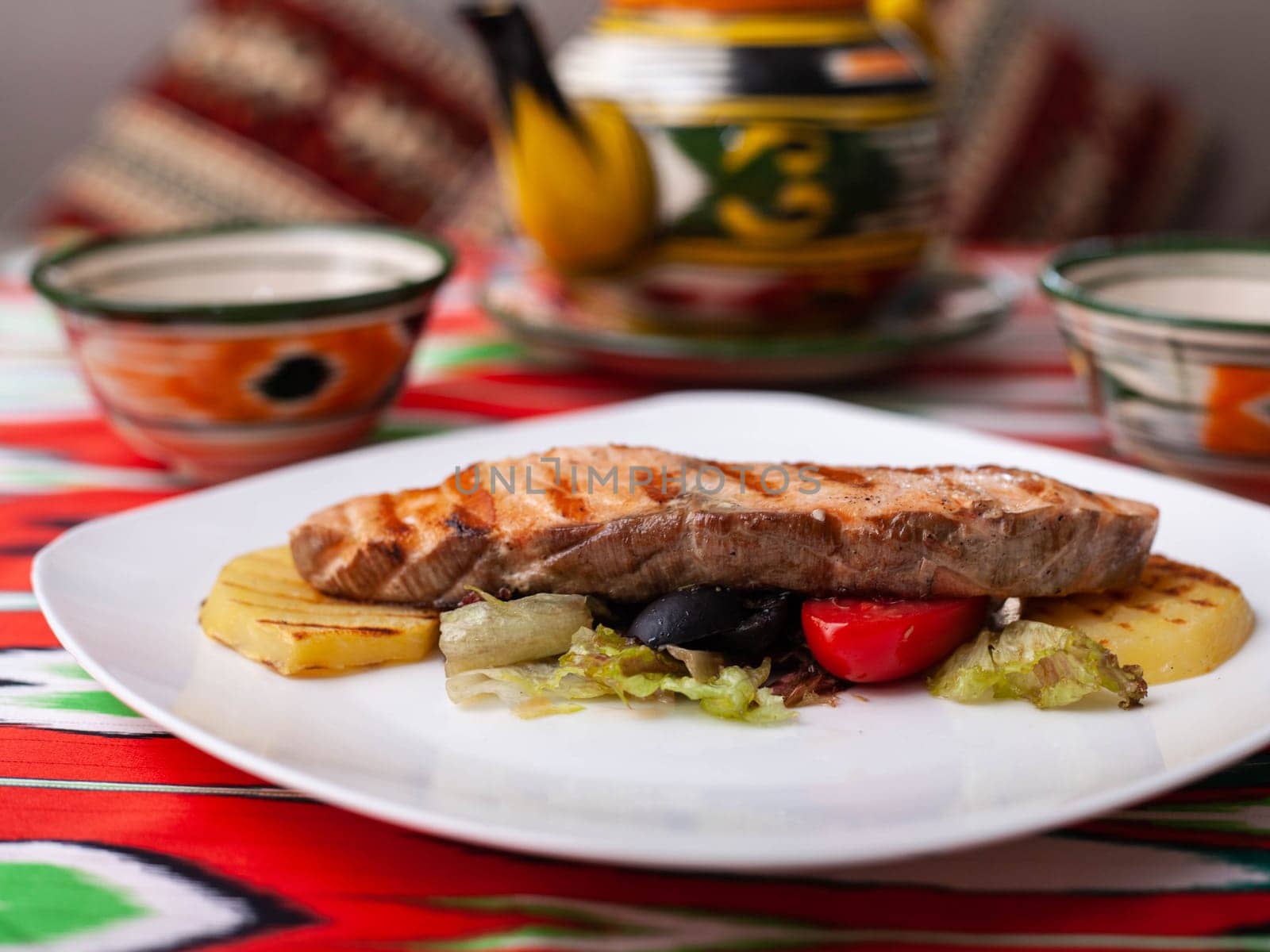 Salmon steak on a pillow of stewed vegetables. Asian style. High quality photo