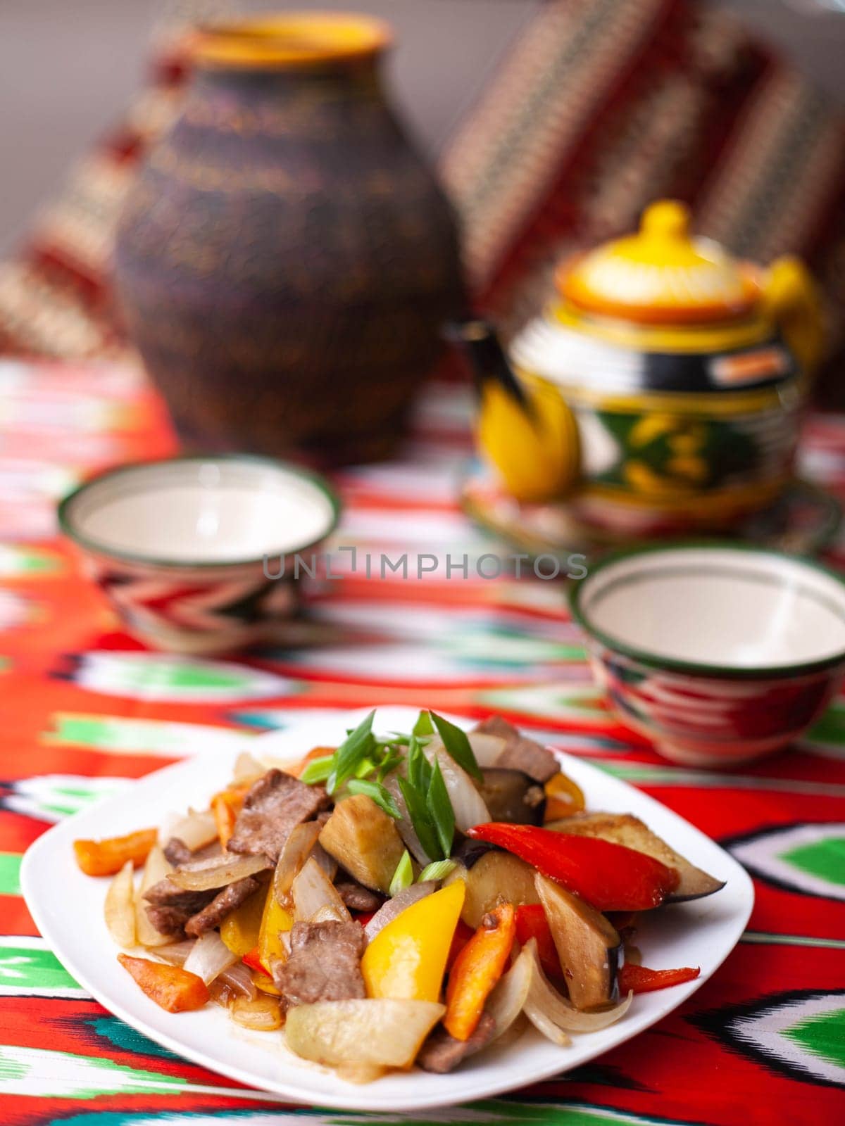 Fried beef meat in oil with potatoes, onions, bell peppers according to the Uyghur recipe. Eastern cuisine, national dish. High quality photo