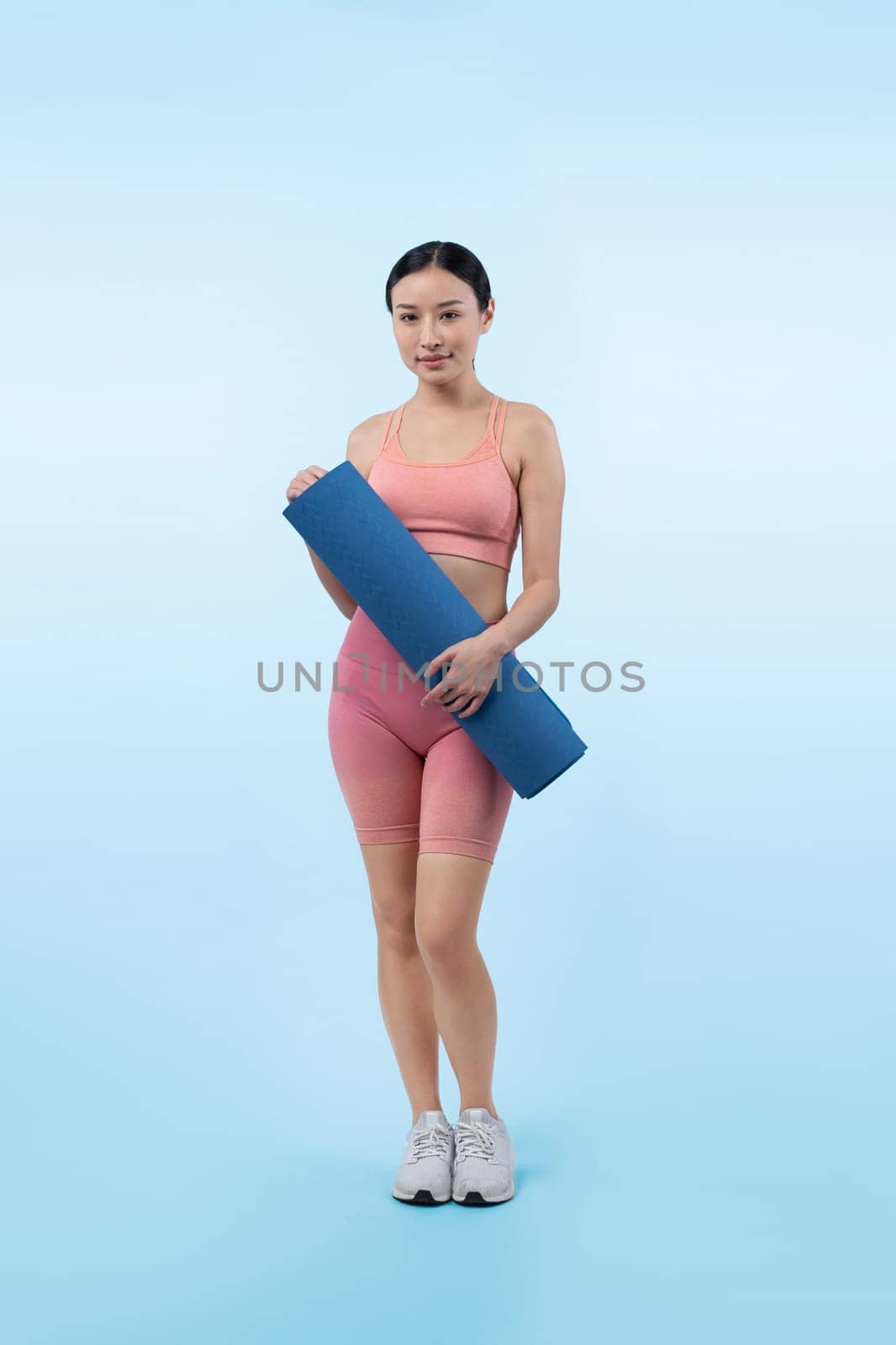 Young attractive asian woman portrait in sportswear with exercising mat. Healthy exercise and workout routine lifestyle concept. Studio shot isolated background. Vigorous