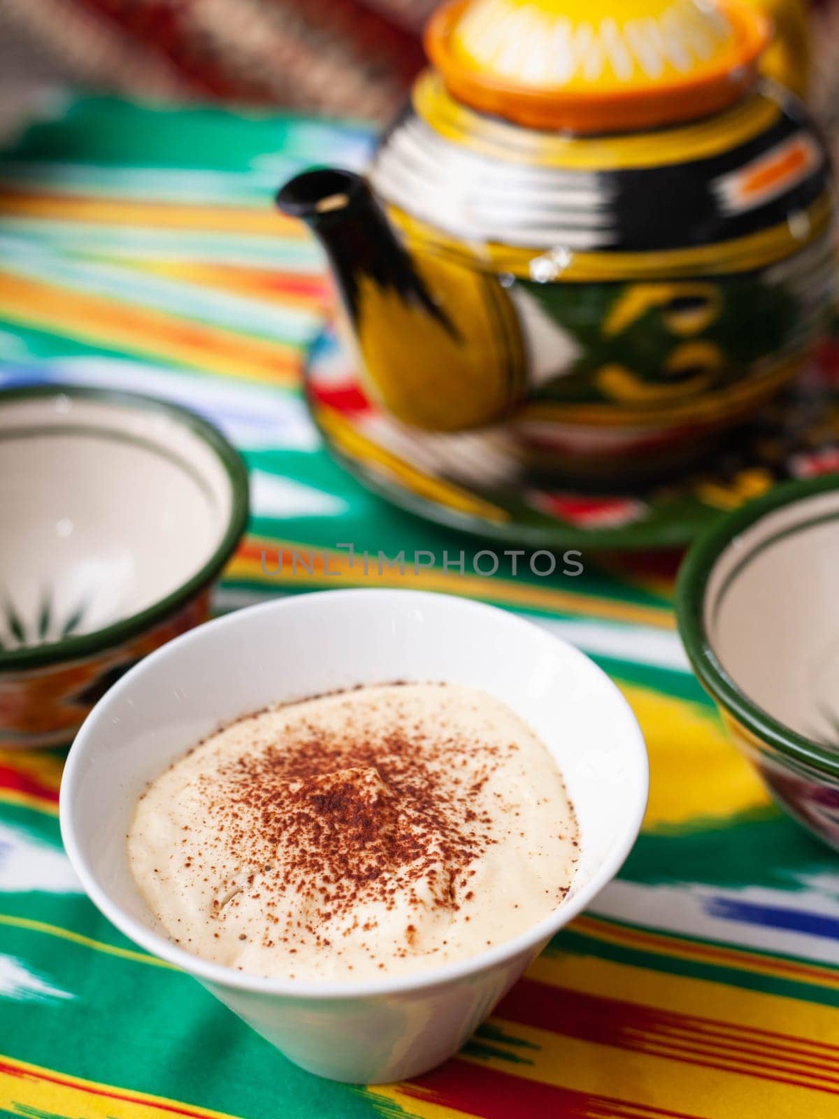 Tiramisu dessert in oriental style with a teapot and a cup for tea. High quality photo