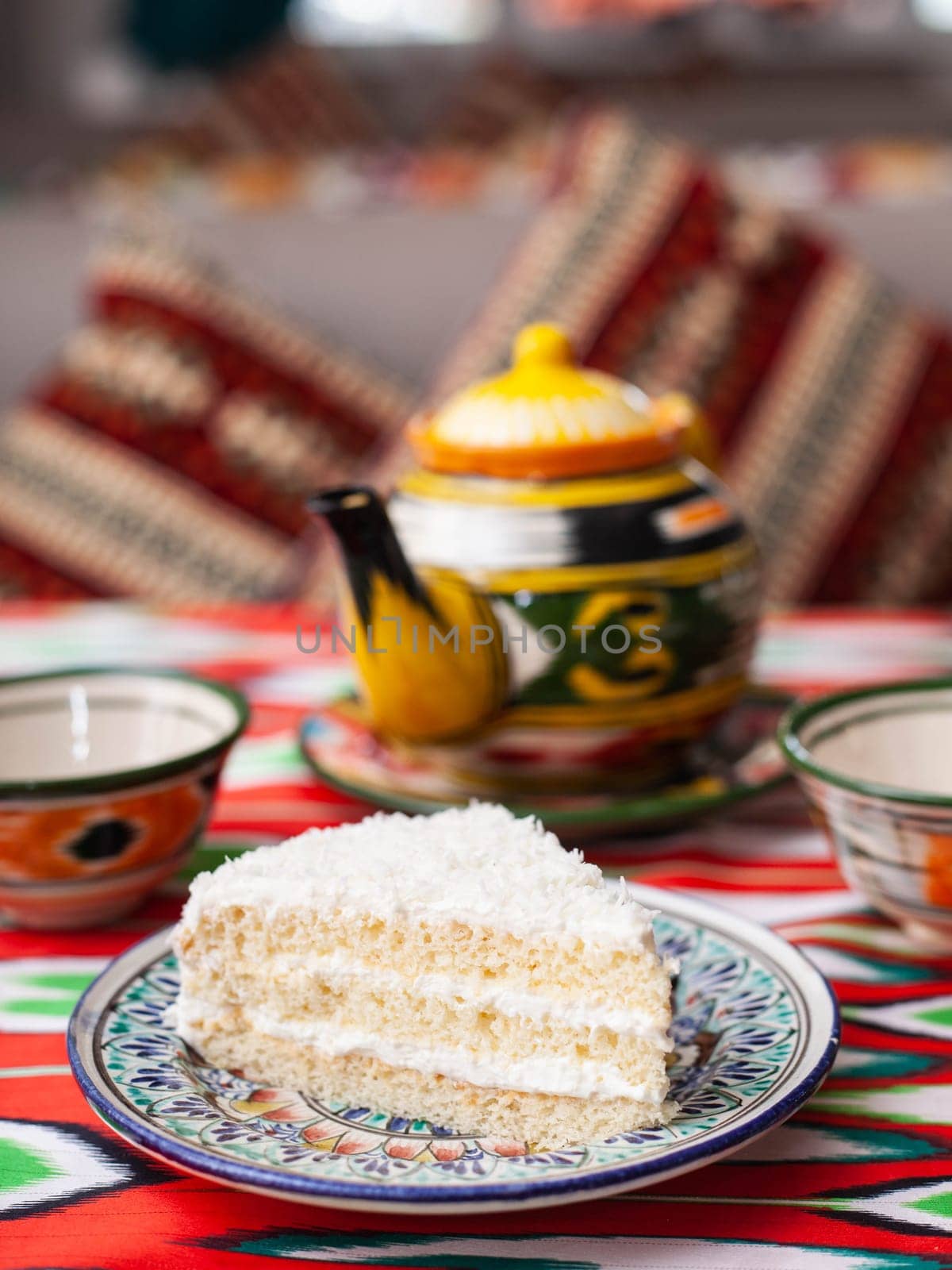 dessert milk girl with white cream and coconut in oriental style on a rooftop with a teapot and a cup for tea. High quality photo