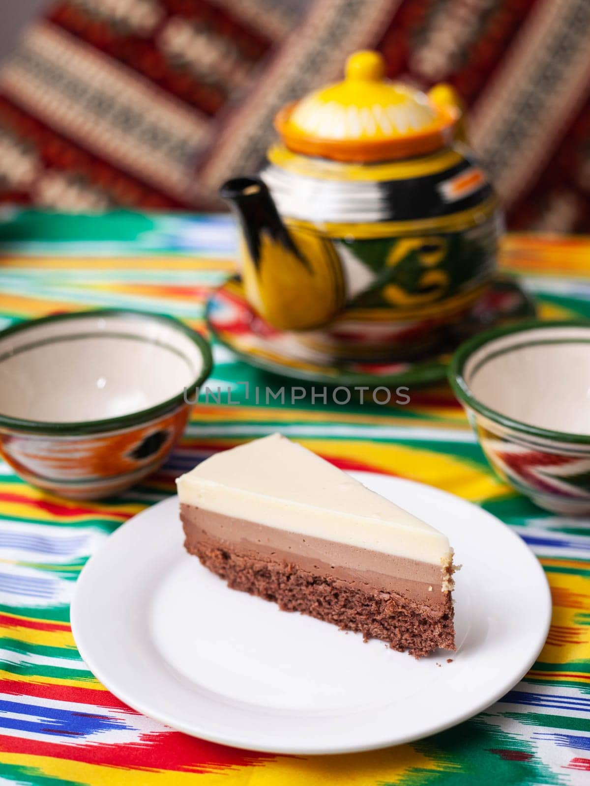 dessert cheesecake three chocolates in an oriental style with a teapot and a cup for tea. High quality photo