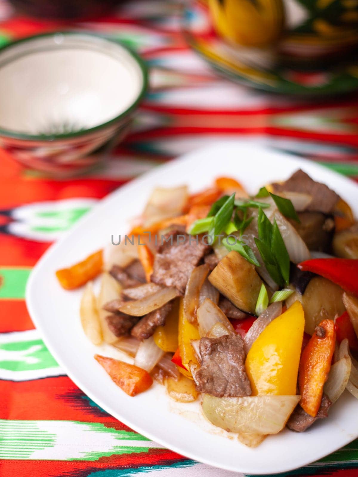 Fried beef meat in oil with potatoes, onions, bell peppers according to the Uyghur recipe. Eastern cuisine, national dish. High quality photo