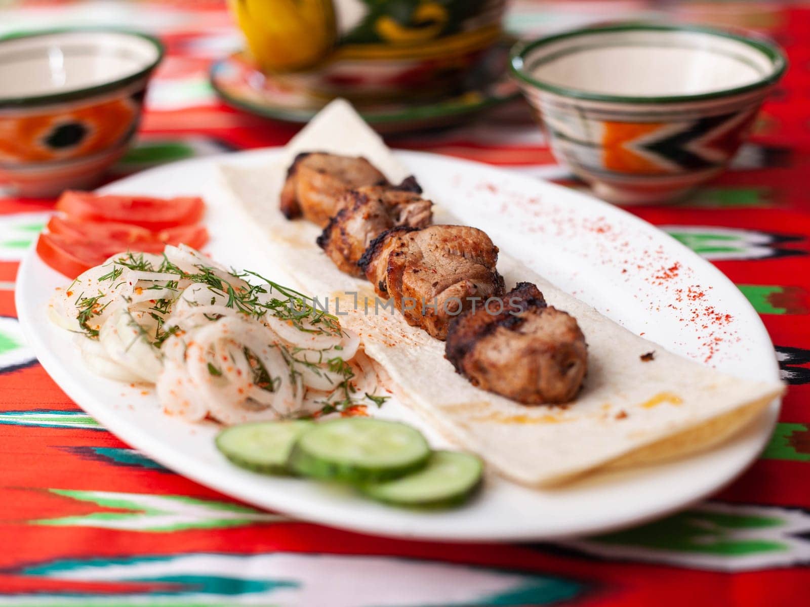 Chicken ifoksr - charcoal grilled chicken breast. Served with vegetables, pickled onions, lavash bread and oriental sauce. Eastern cuisine. High quality photo