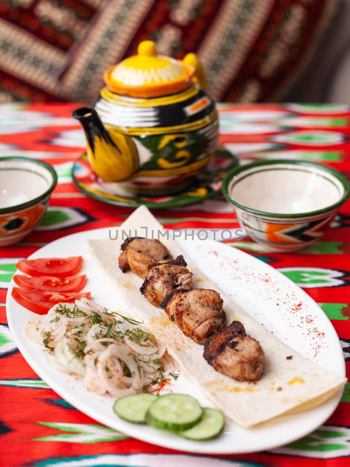 Chicken ifoksr - charcoal grilled chicken breast. Served with vegetables, pickled onions, lavash bread and oriental sauce. Eastern cuisine. High quality photo