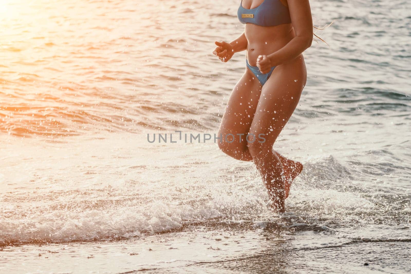 Running woman on a summer beach. A woman jogging on the beach at sunrise, with the soft light of the morning sun illuminating the sand and sea, evoking a sense of renewal, energy and health. by panophotograph