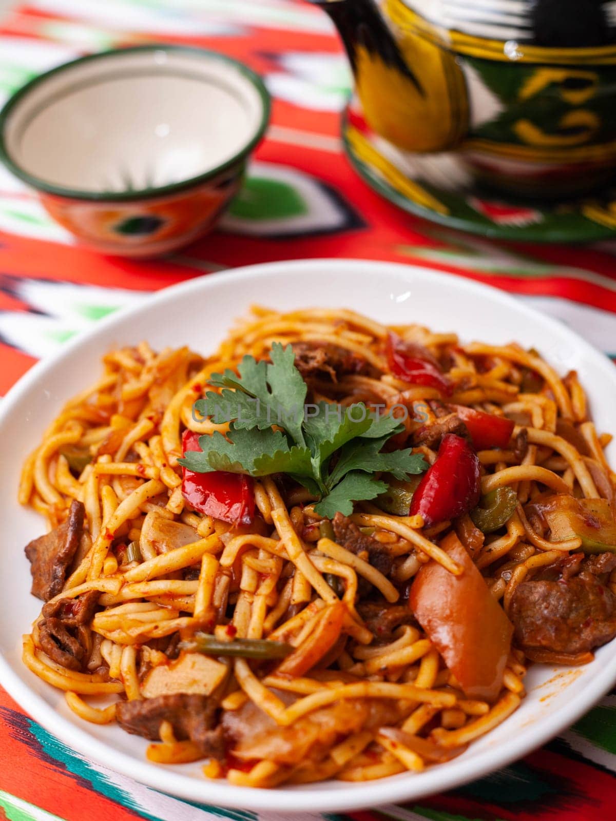 The oriental lagman dish is homemade noodles fried with meat, vegetables and herbs. Eastern cuisine. High quality photo