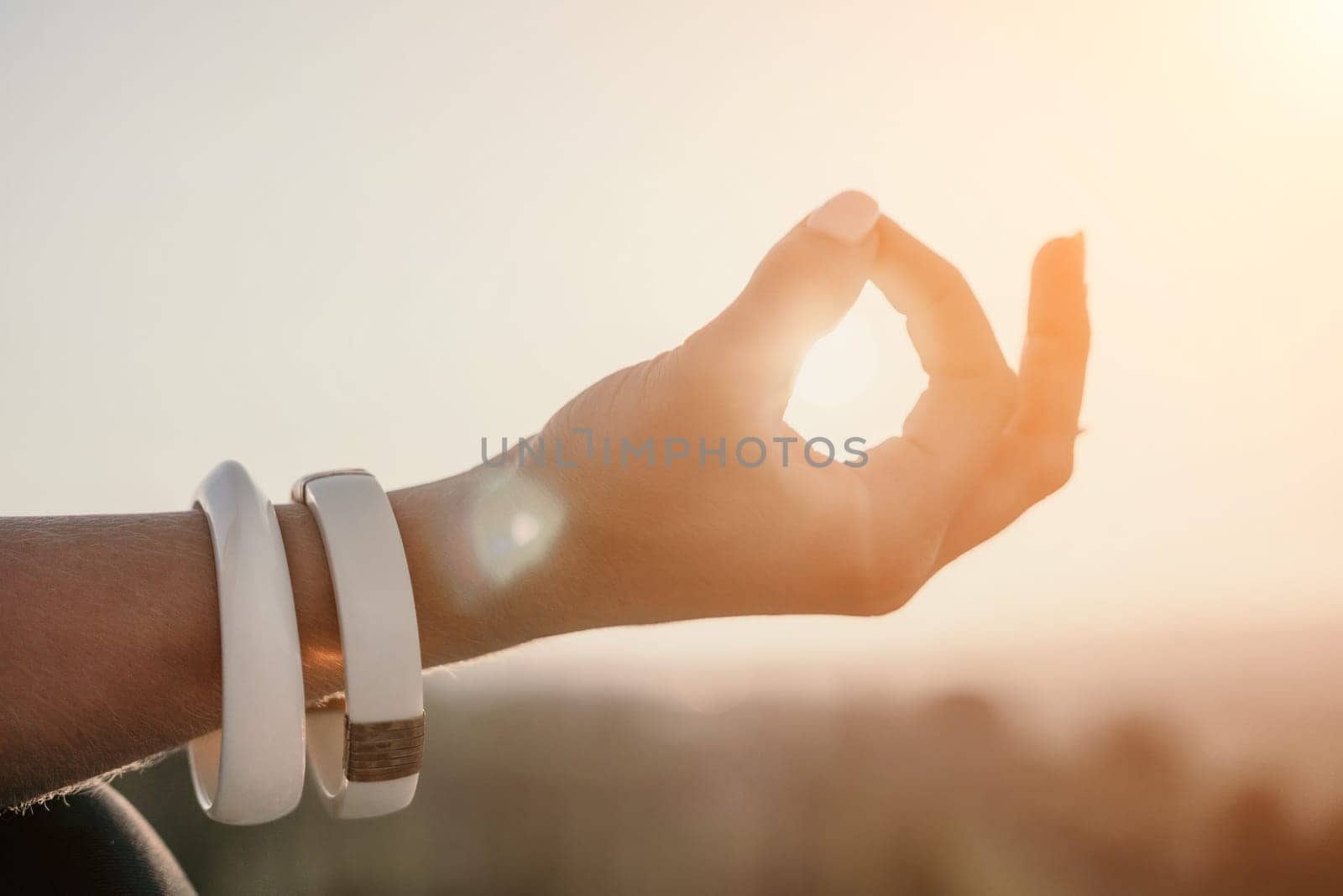 Fitness woman. Happy middle-aged fitness woman doing stretching and pilates on a rock near forest at sunset. Female fitness yoga routine. Healthy lifestyle with focus on well-being and relaxation. by panophotograph