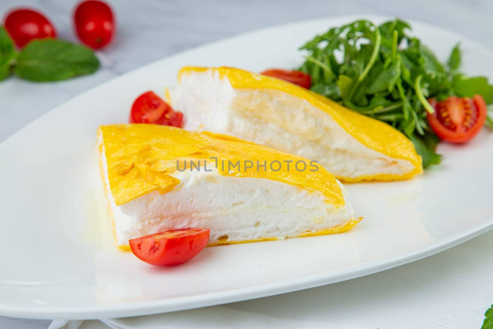 French tall omelette with arugula and cherry tomatoes side view by tewolf