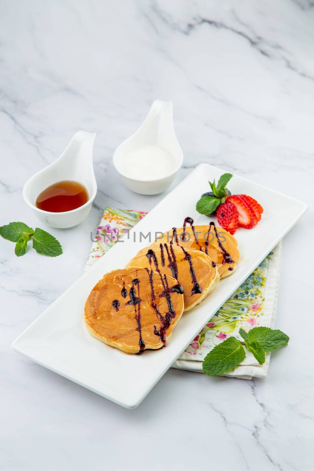 pancakes with chocolate syrup with strawberries