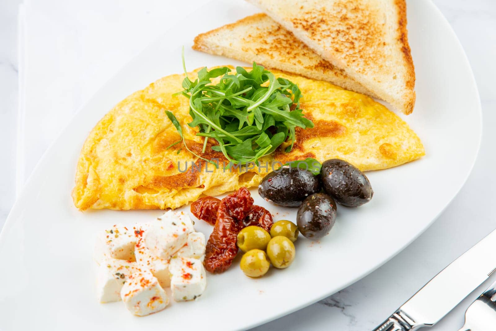 Breakfast of eggs with meat, herbs and drops of sauce with bread in a round plate side view by tewolf