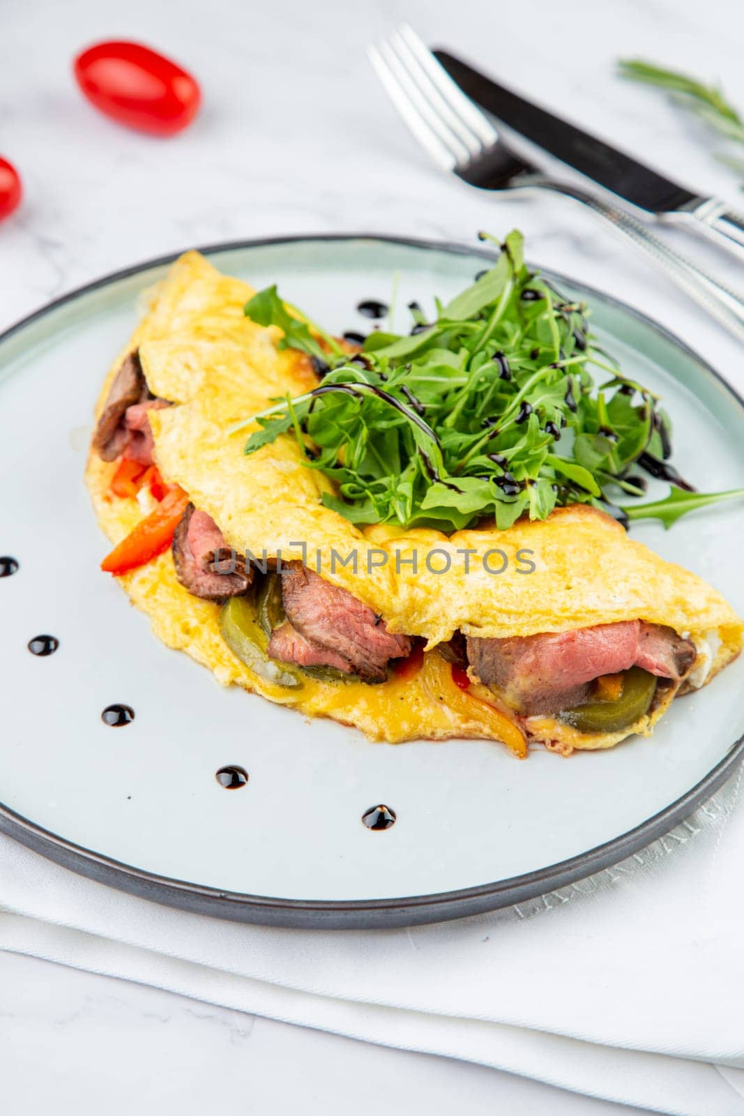 Breakfast of eggs with meat, herbs and drops of sauce in a round plate side view by tewolf