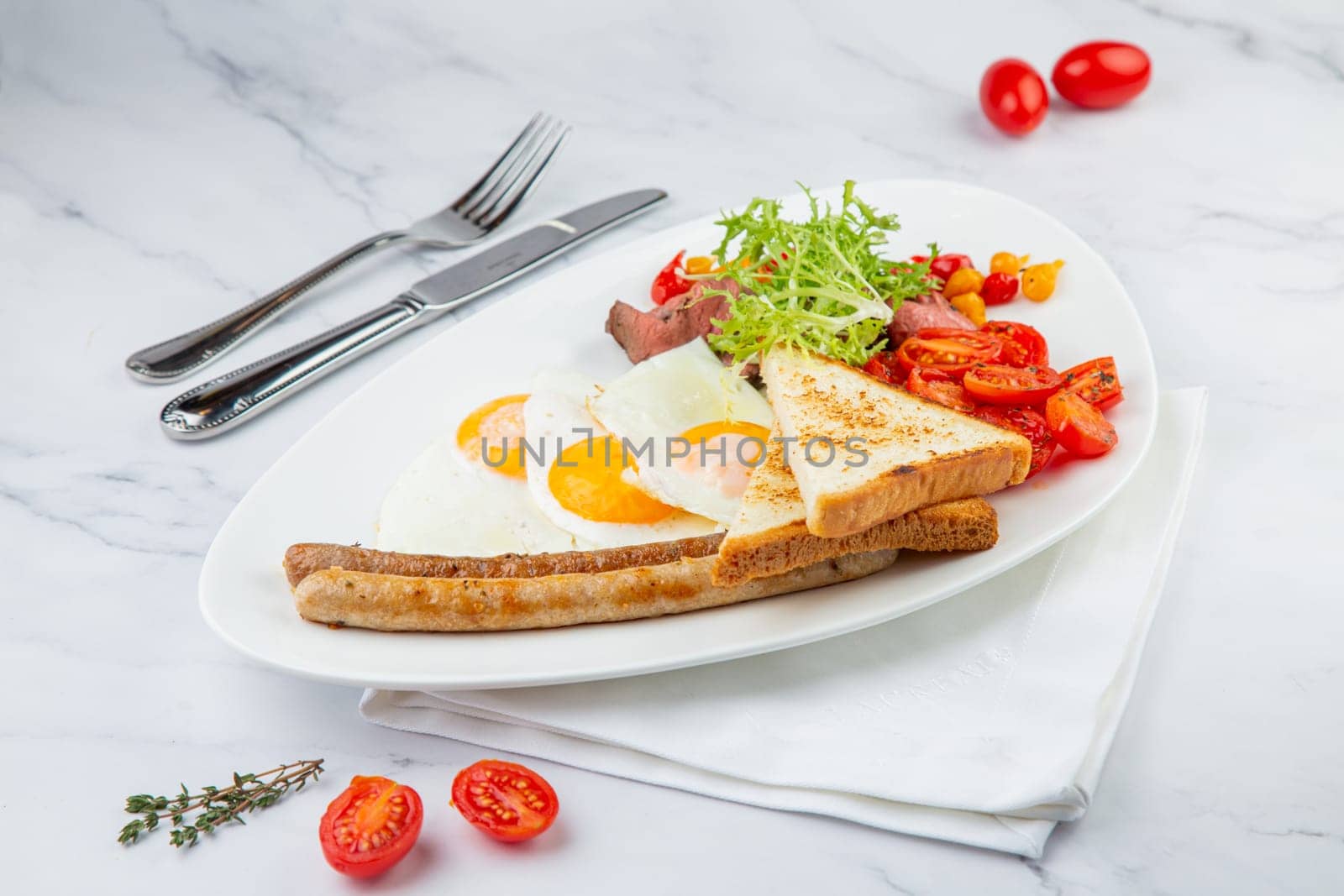 scrambled eggs with vegetables, cherry tomatoes, bread, herbs and sausages