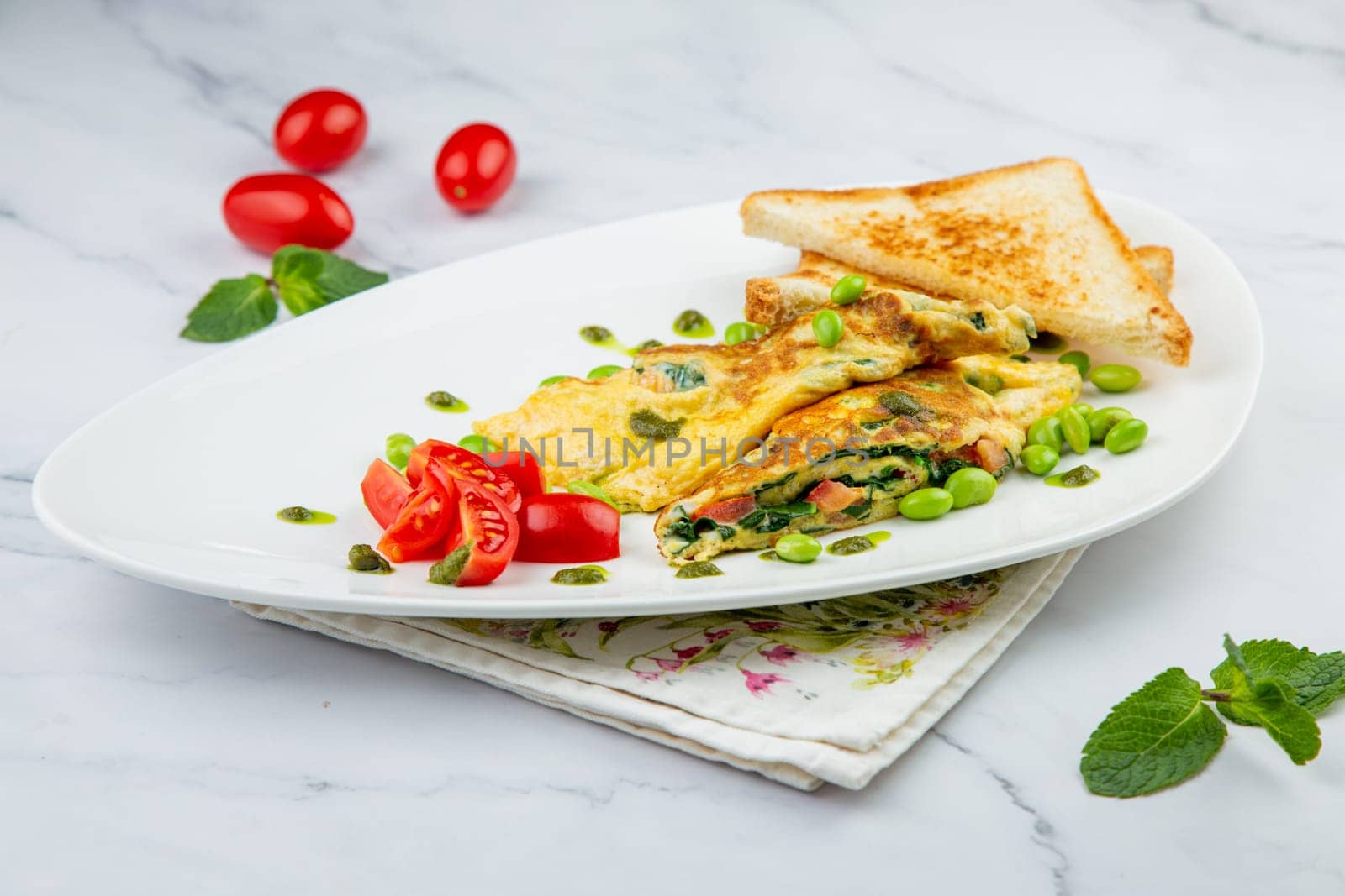 Breakfast of eggs and vegetables with cherry tomatoes and slices of bread in a white plate side view by tewolf