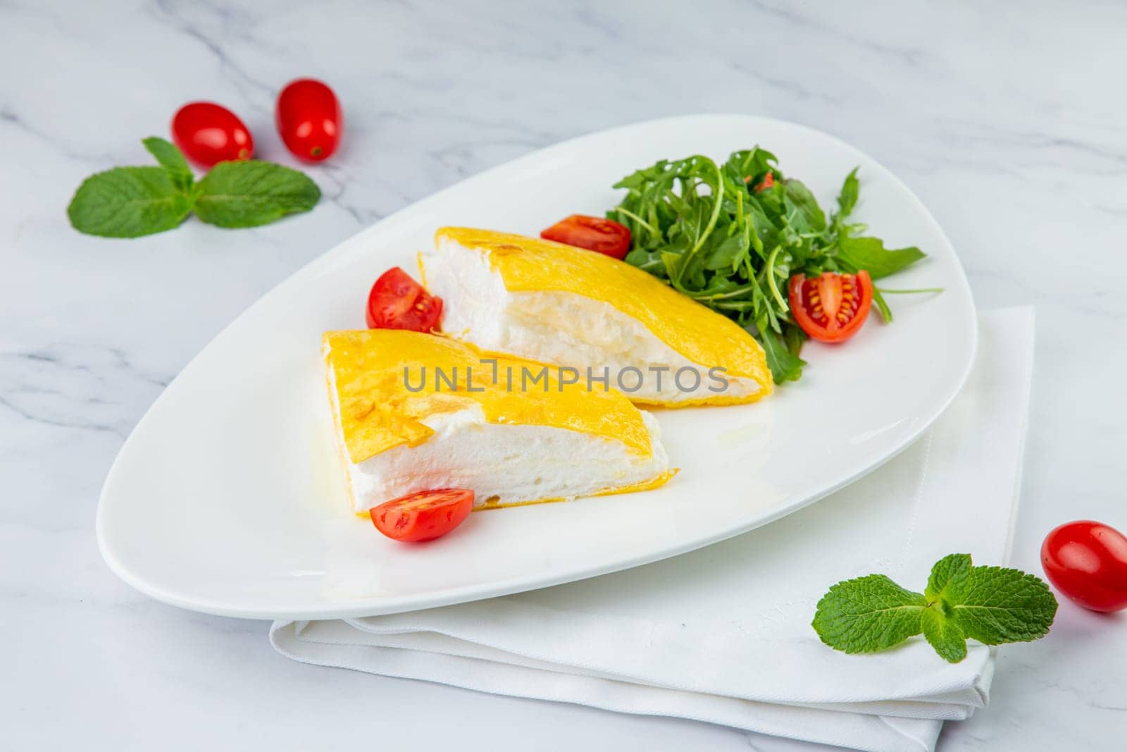 French tall omelette with arugula and cherry tomatoes side view by tewolf