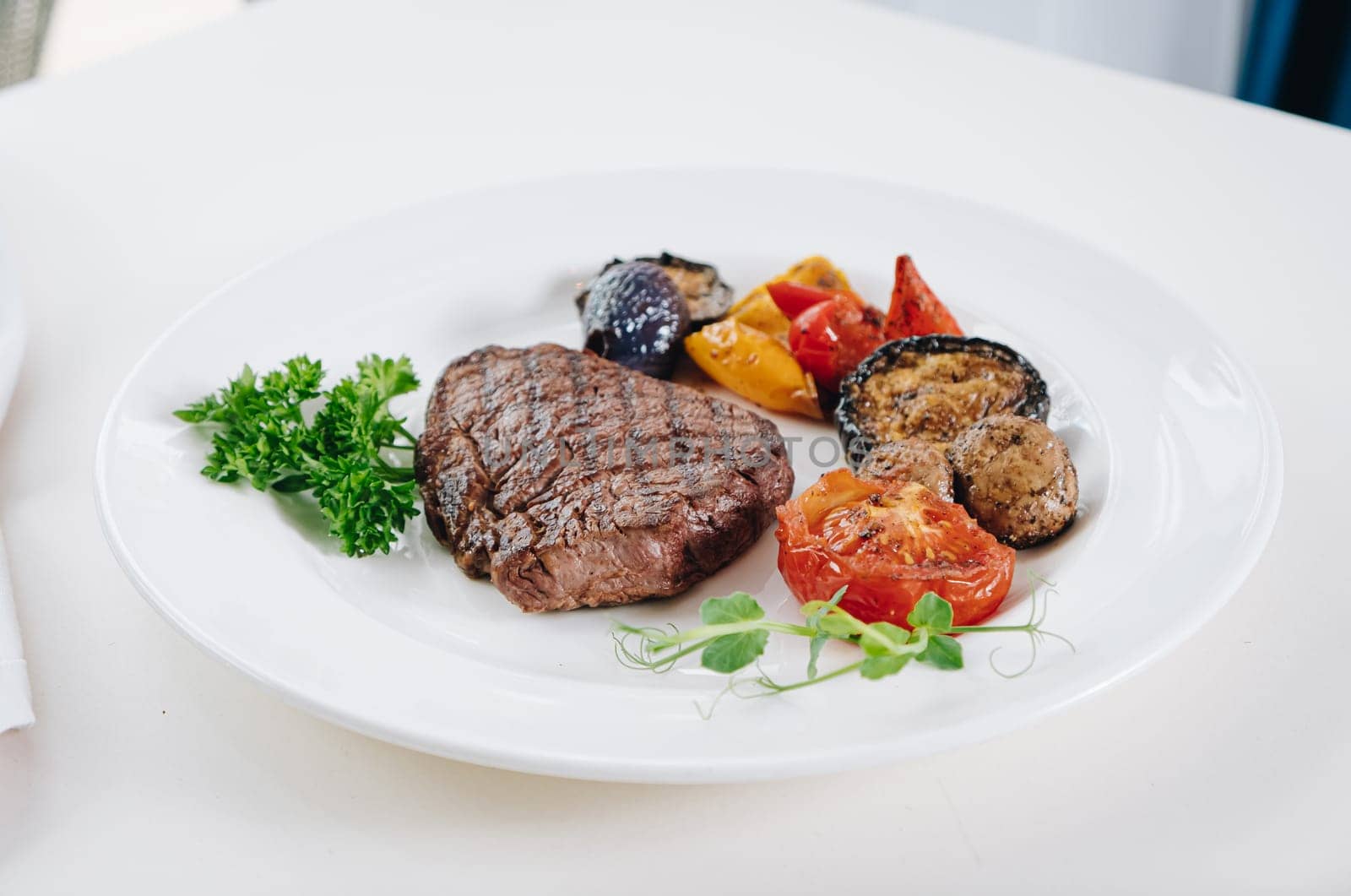 beef steak with grilled vegetables and herbs on a light background by tewolf