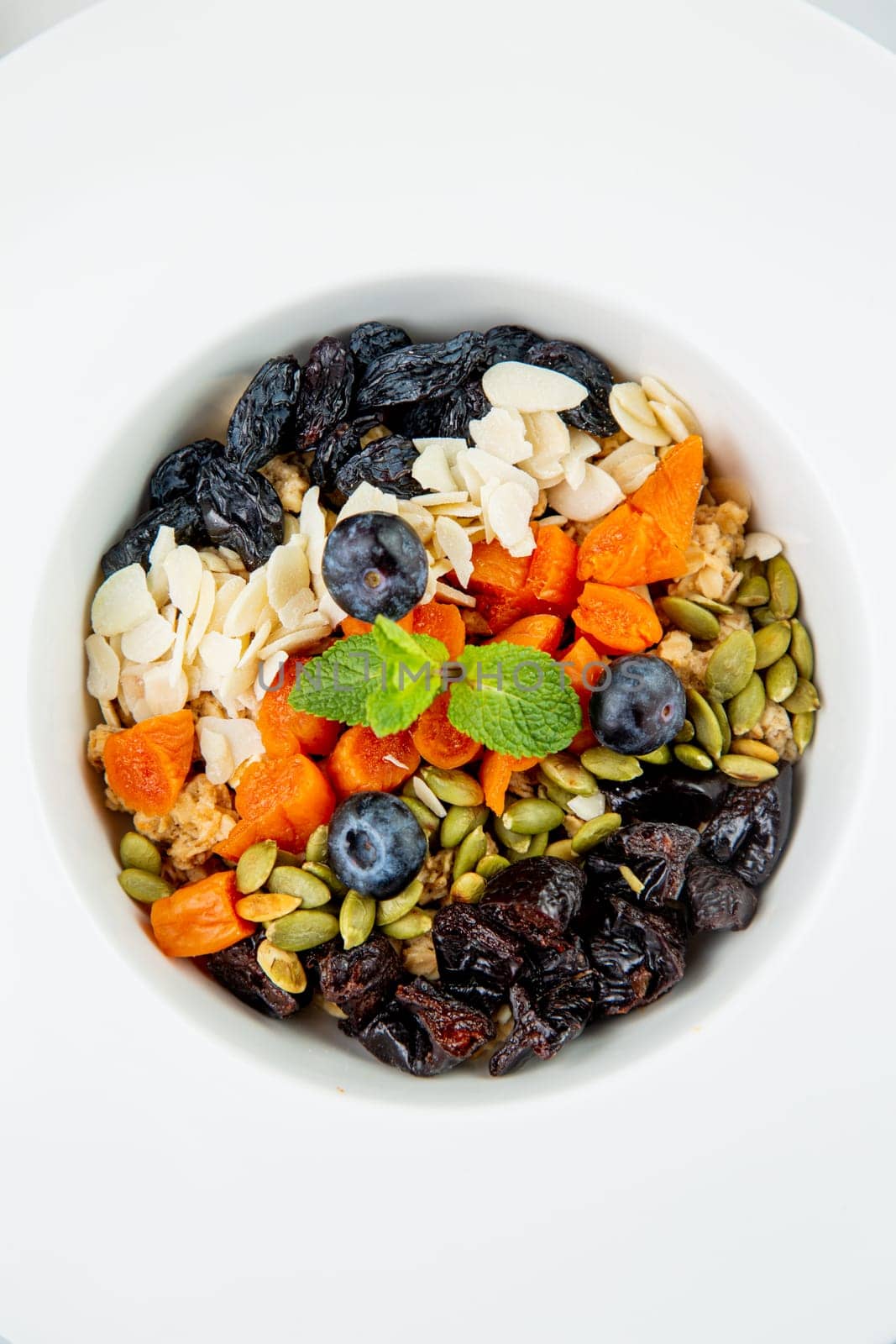 deep plate with cereals, berries, pistachios, dried apricots and raisins