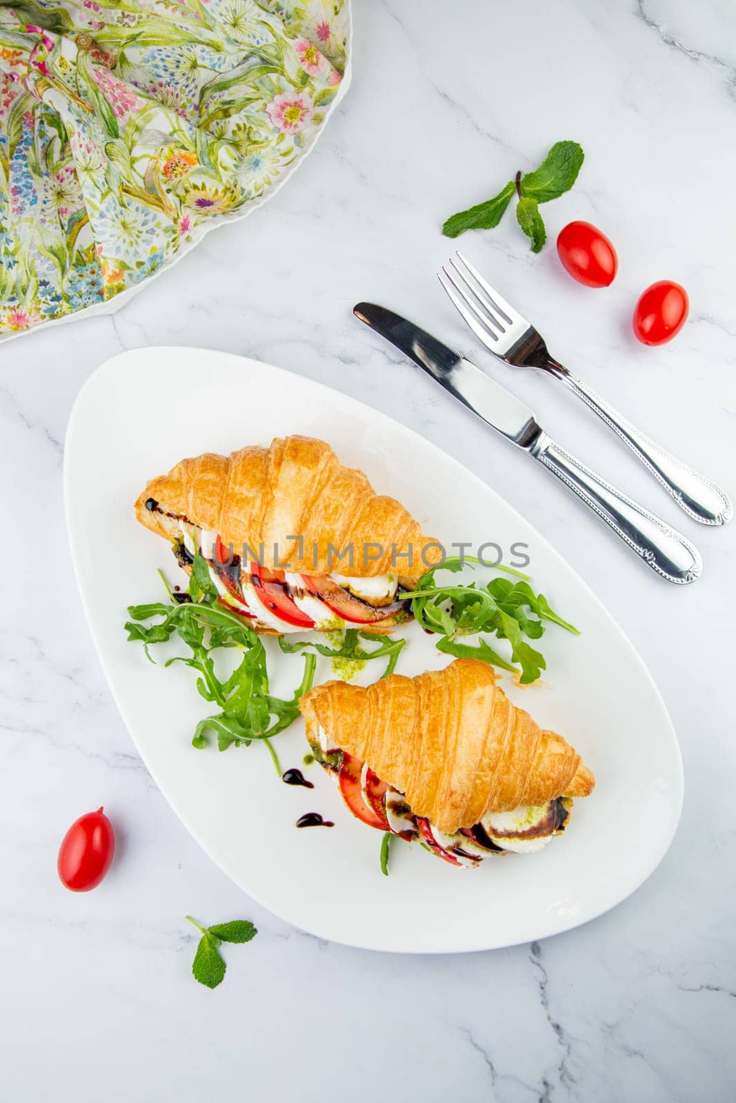 croissants with cheese, vegetables, cherry tomatoes and herbs top view by tewolf