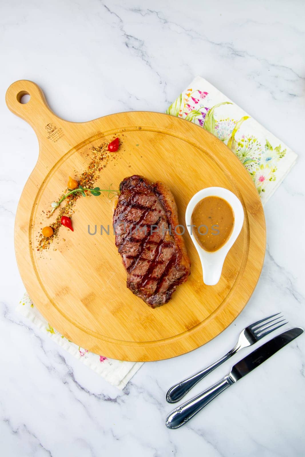 beef steak with spices and sauce on a wooden tray top view by tewolf