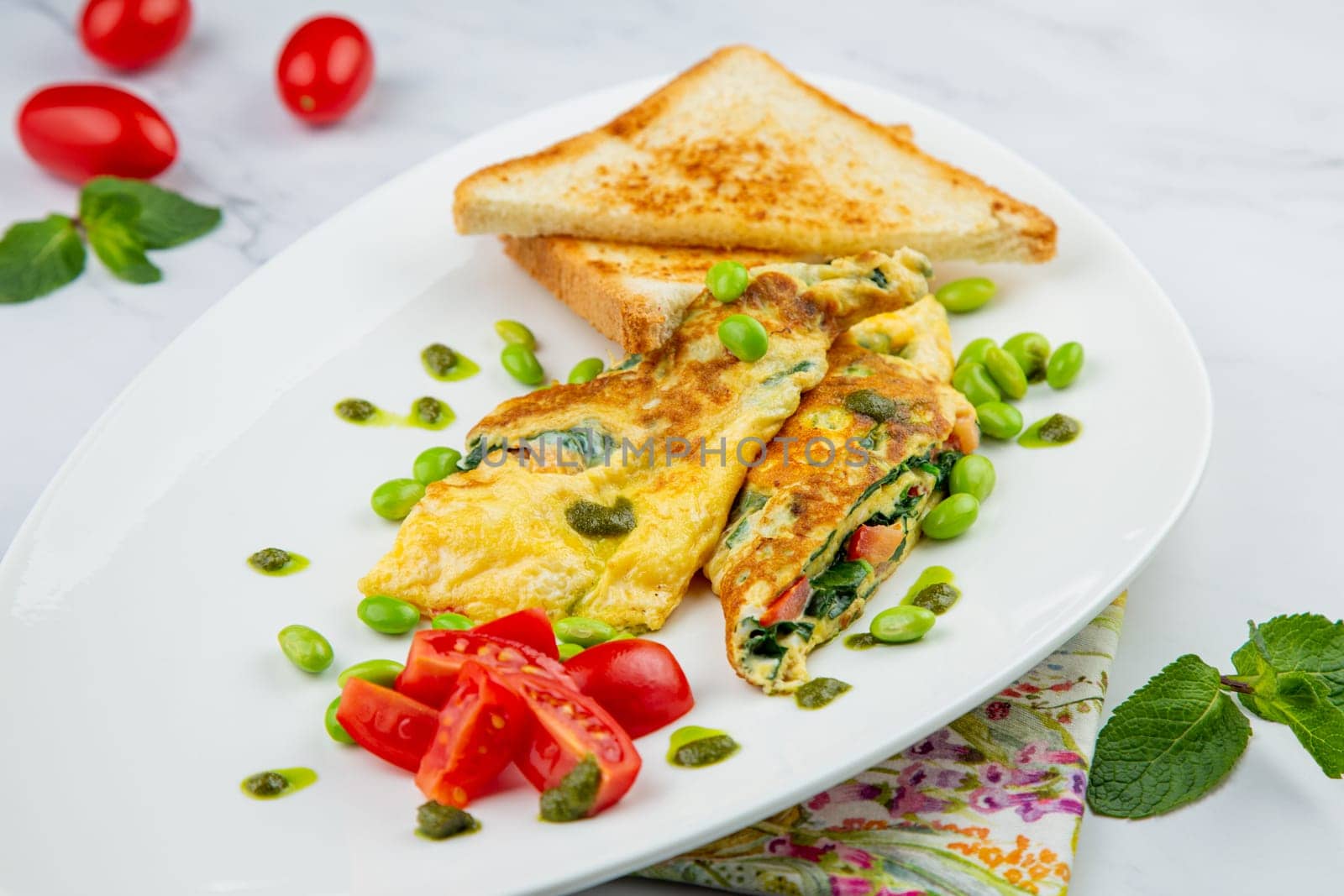 Breakfast of eggs and vegetables with cherry tomatoes and slices of bread in a white plate side view by tewolf