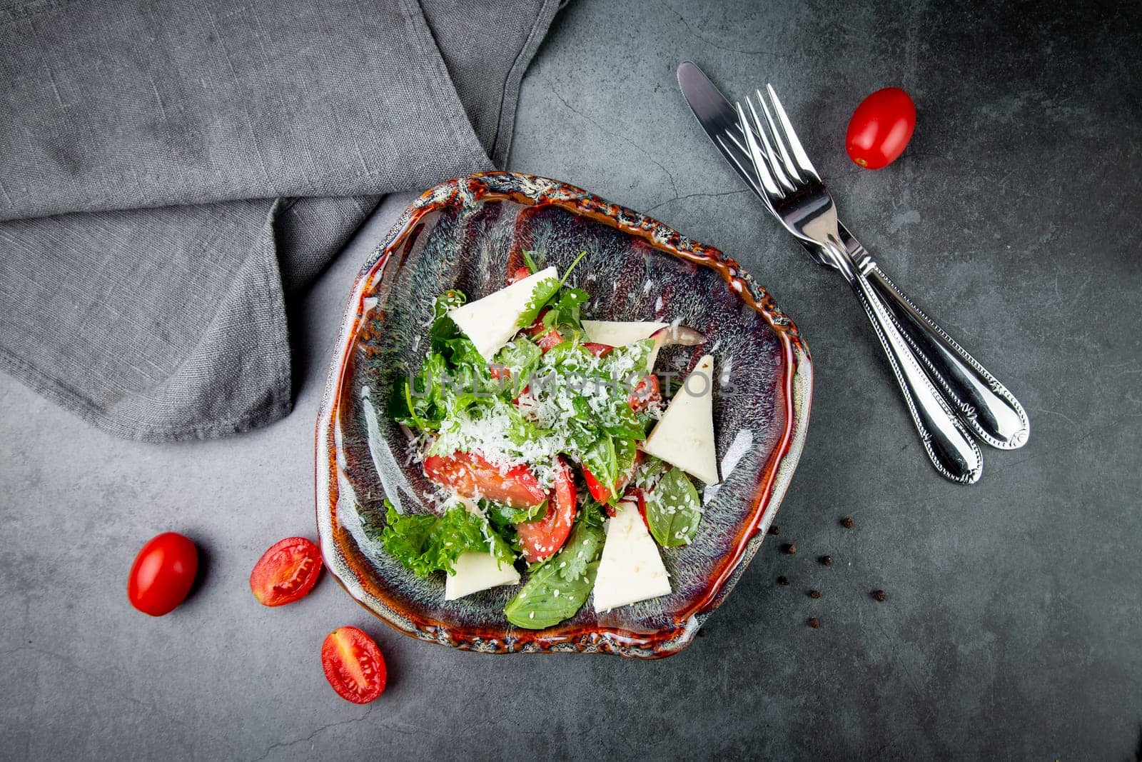 salad with tomatoes, feta cheese, lettuce and parsley in an unusual bowl side view by tewolf