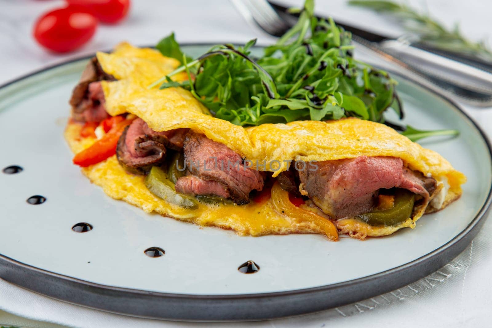 Breakfast of eggs with meat, herbs and drops of sauce in a round plate side view by tewolf