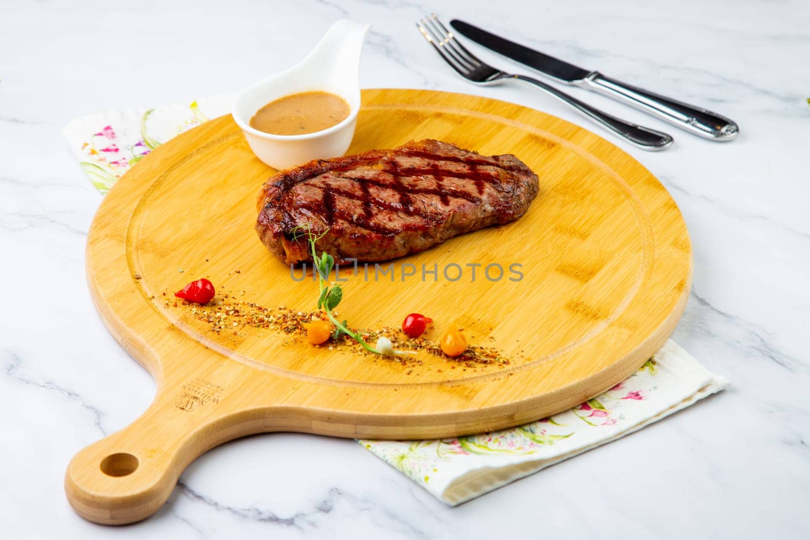 beef steak with spices and sauce on a wooden tray side view by tewolf