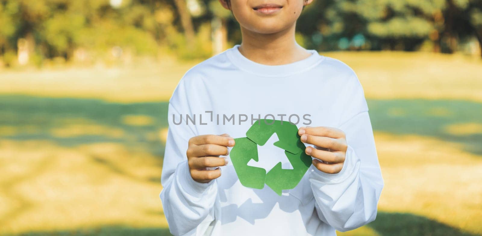 Cheerful young asian boy holding recycle symbol. Gyre by biancoblue