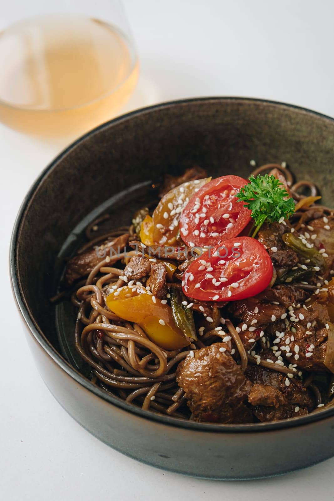 noodles with beef, vegetables, cherry tomatoes and sesame sauce