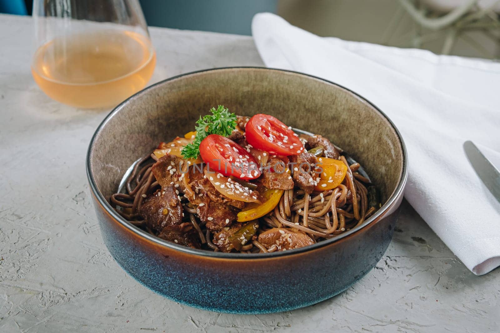 noodles with beef, vegetables, cherry tomatoes and sesame sauce