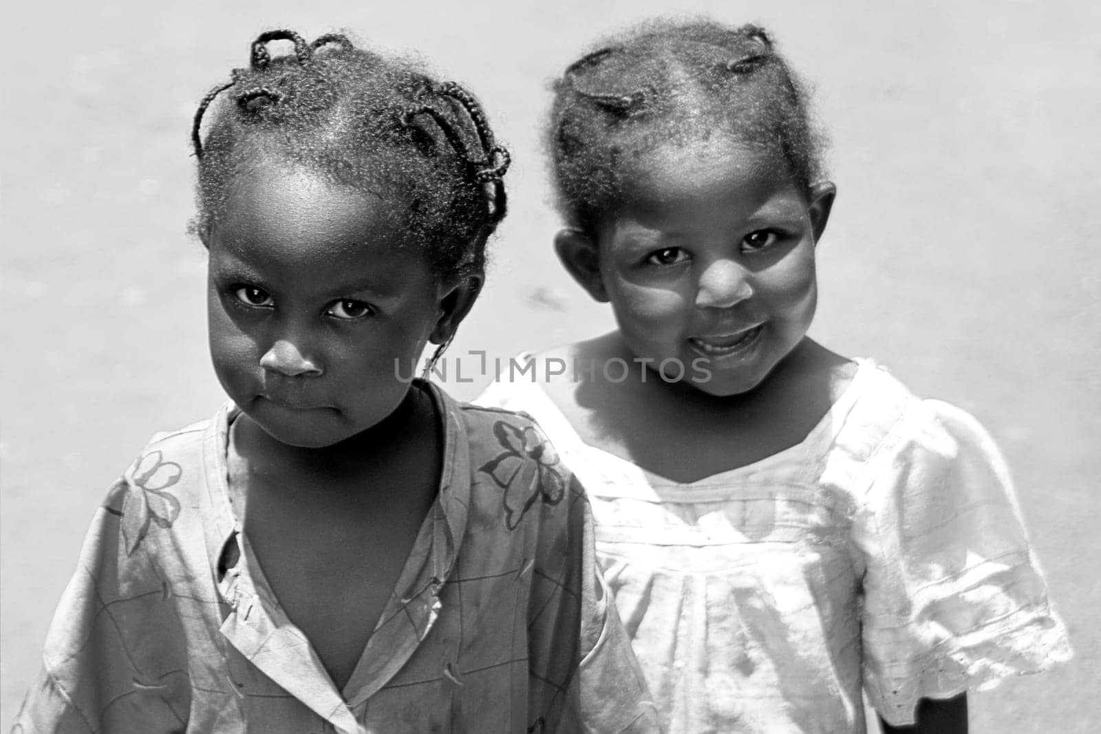 These two girls have never seen a white man,they come from the countryside... One is curious,the other is a bit afraid. I then showed them their picture on the display of my camera,they were amazed at first,then they found