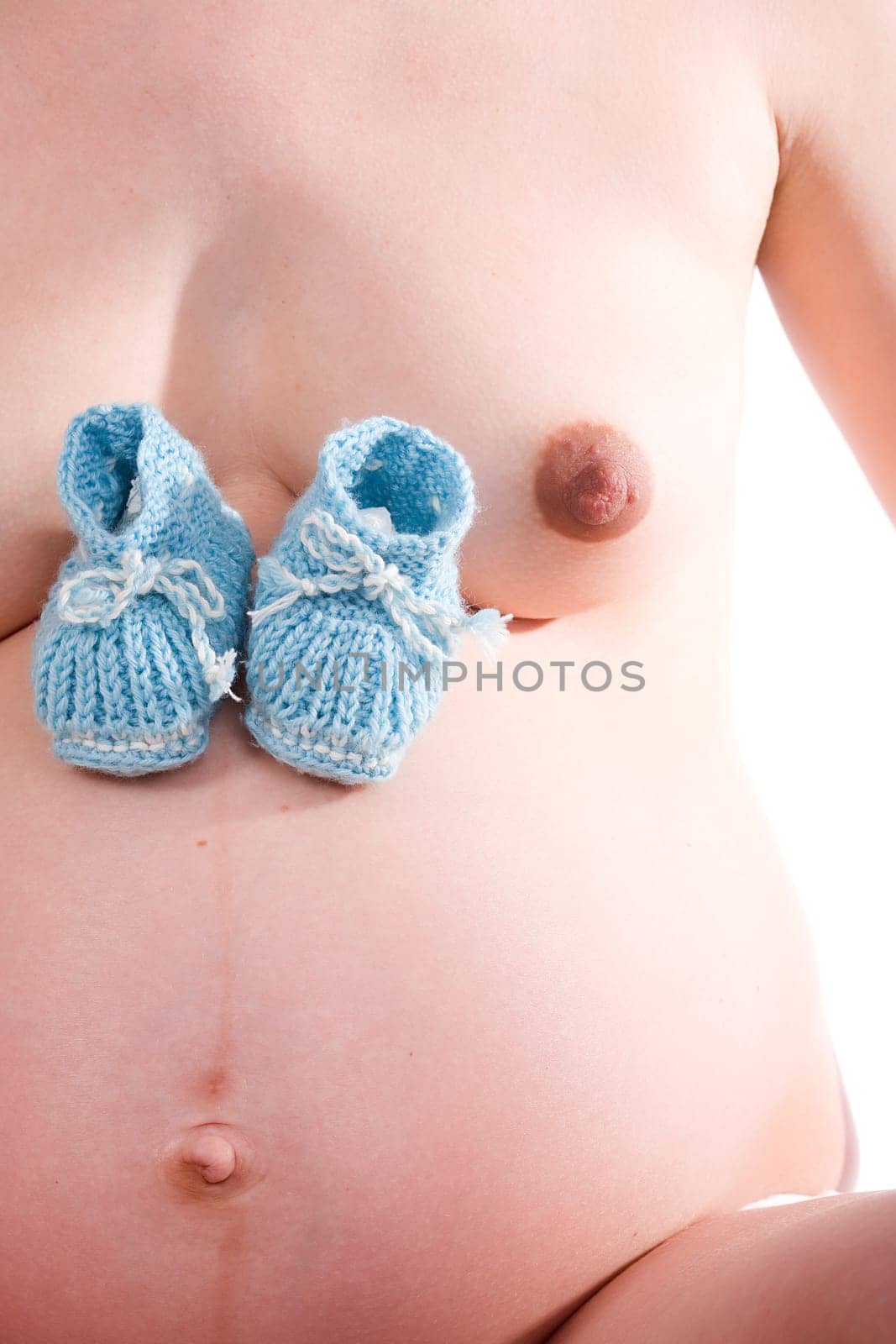Blue baby shoes on belly