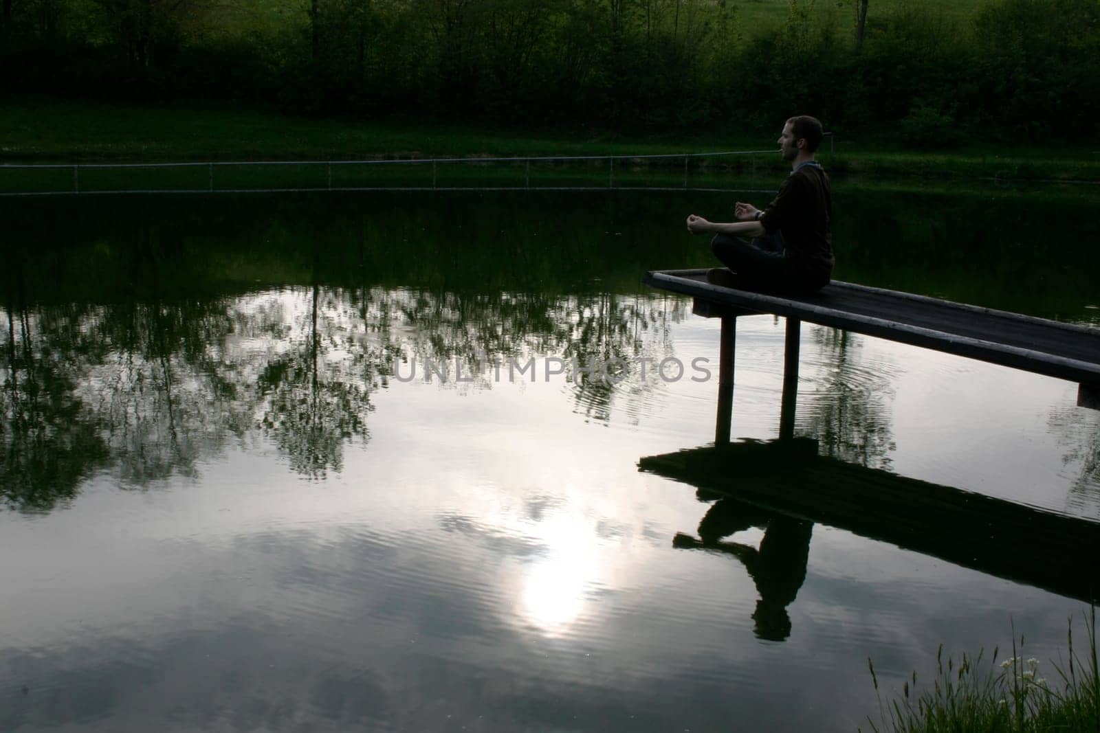 Man sitting on jetty in the evening sun