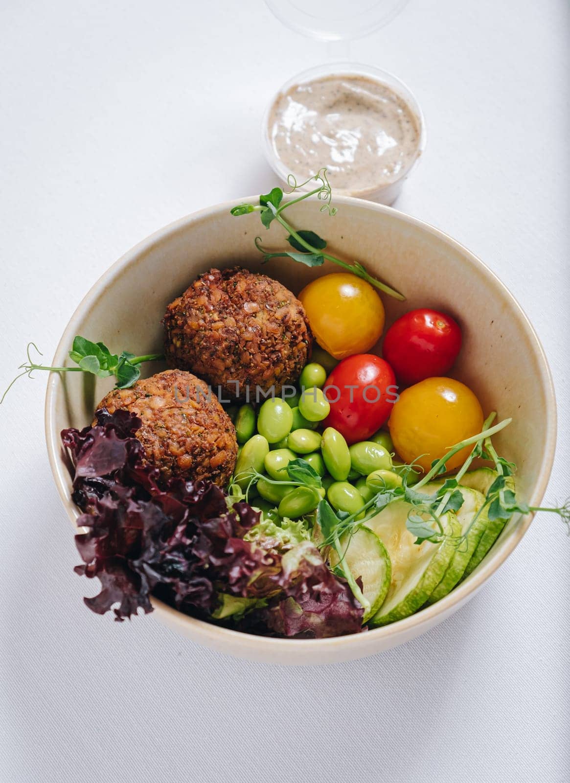 bowl in Chinese style.meatballs with beans, herbs, cherry tomatoes and sauce in a bowl by tewolf