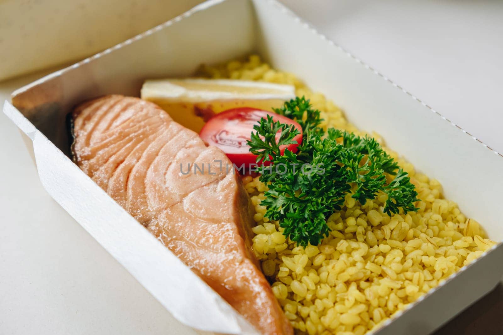 food in containers. proper nutrition, daily diet, weight loss. greens, tomato, lemon salmon steak with couscous side dish. Top view by tewolf