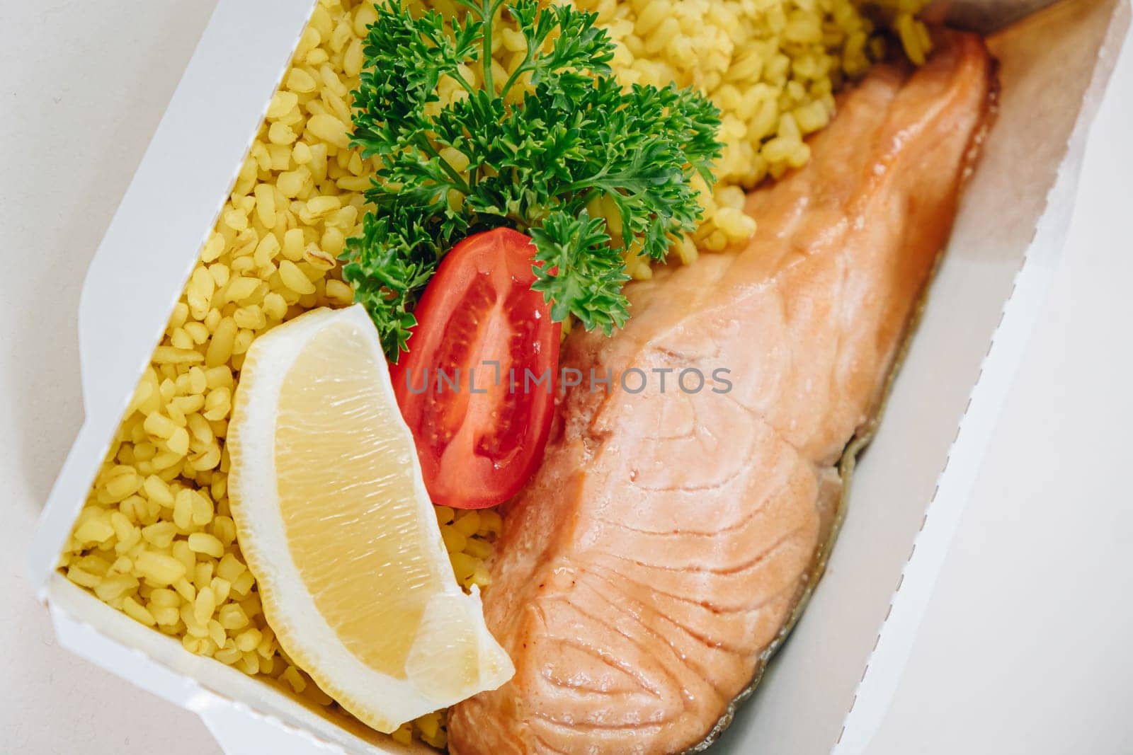 food in containers. proper nutrition, daily diet, weight loss. greens, tomato, lemon salmon steak with couscous side dish. Top view by tewolf