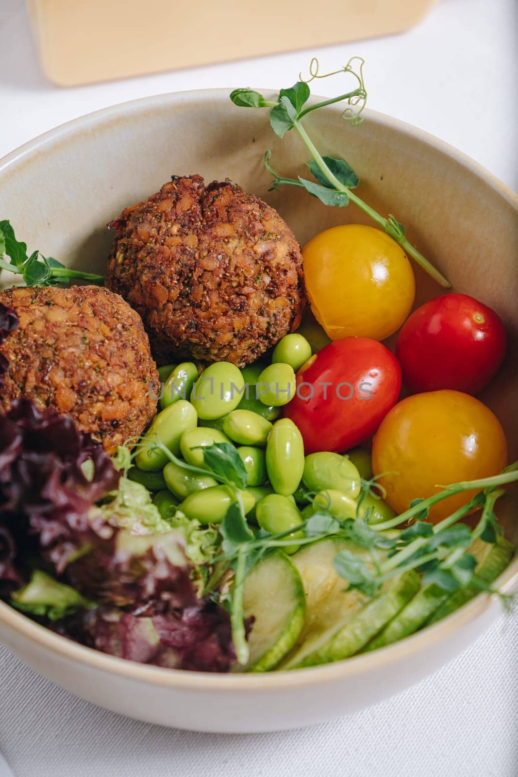 bowl in Chinese style.meatballs with beans, herbs, cherry tomatoes and sauce in a bowl by tewolf