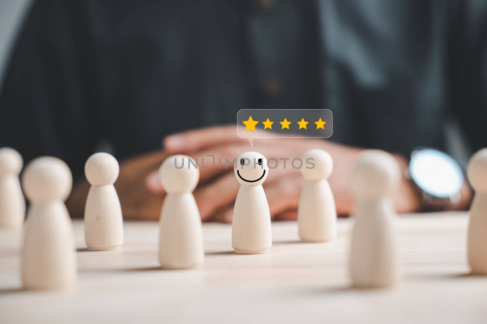Wooden figure representing customer service rating. Hand picked in crowd of people. HR management selects positive leader with happy and smiling face to lead team towards success in business concept.