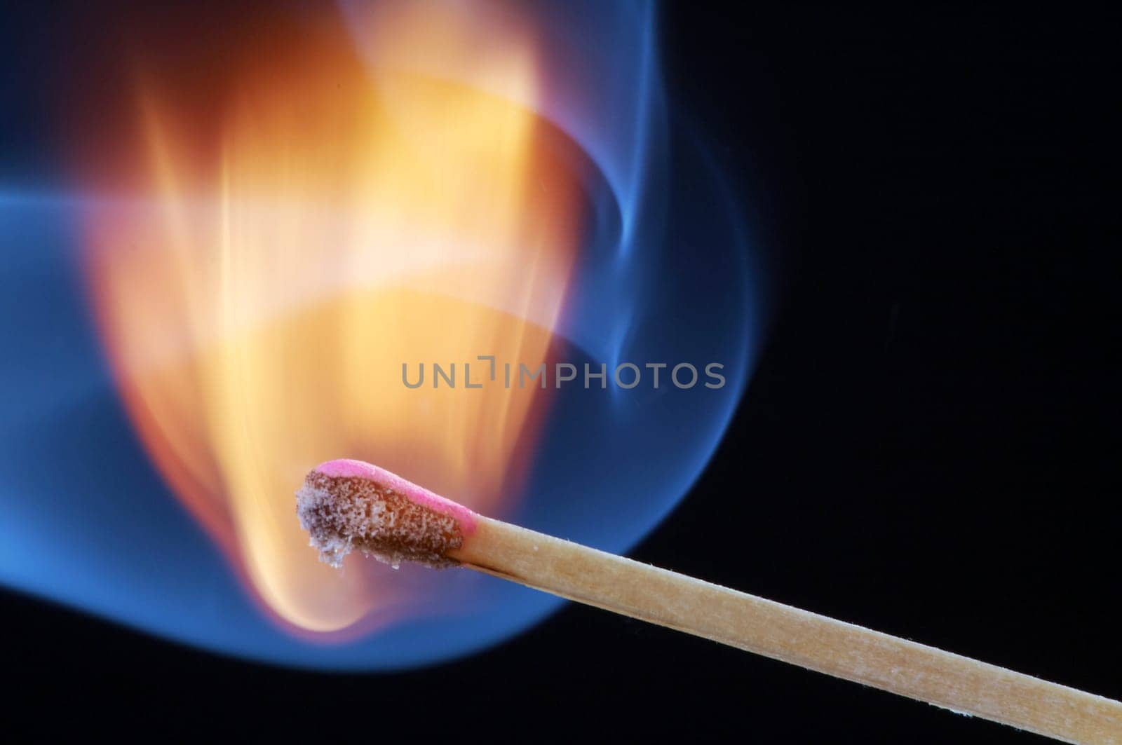 Match that has just been lit against a black background