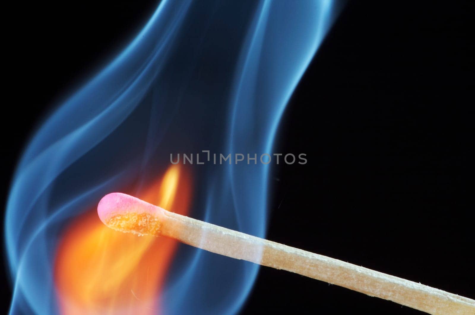 Match that has just been lit against a black background