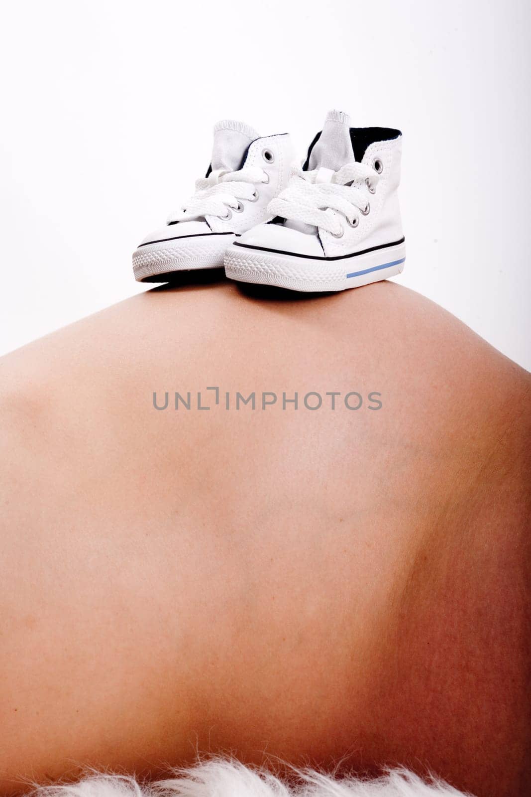 Baby shoes on mother's belly