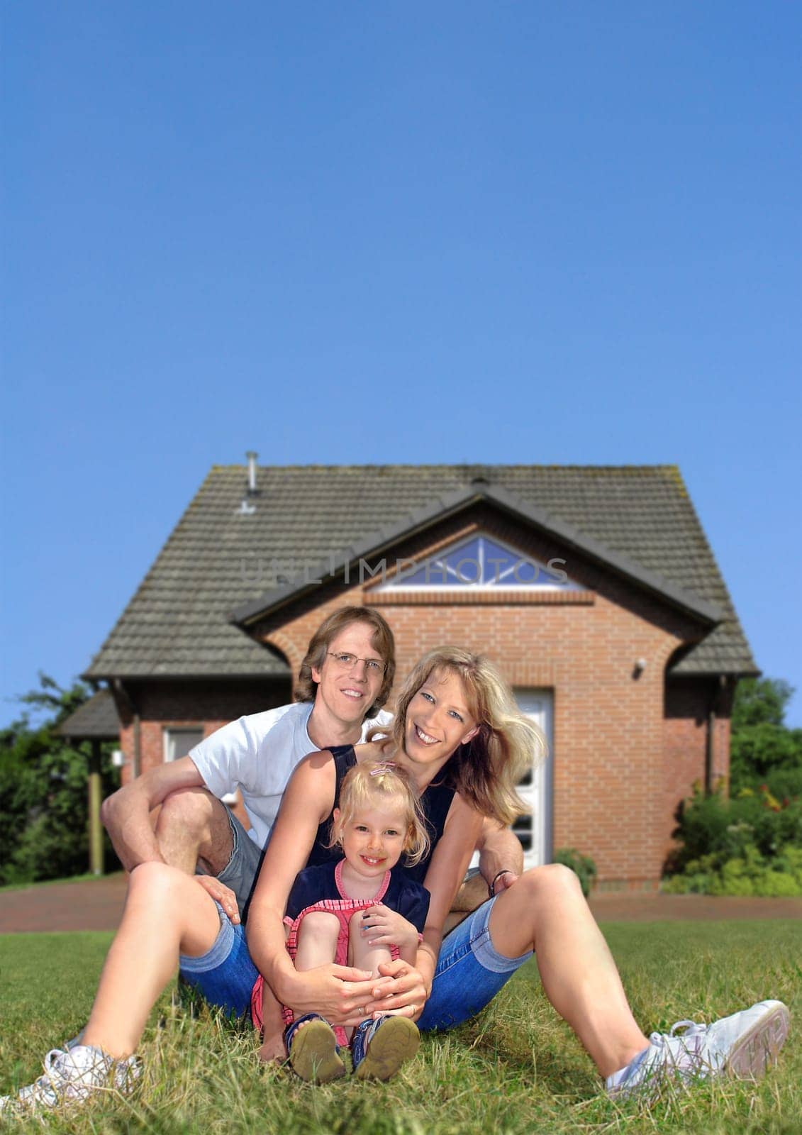 Cheerful family sitting in front of home
