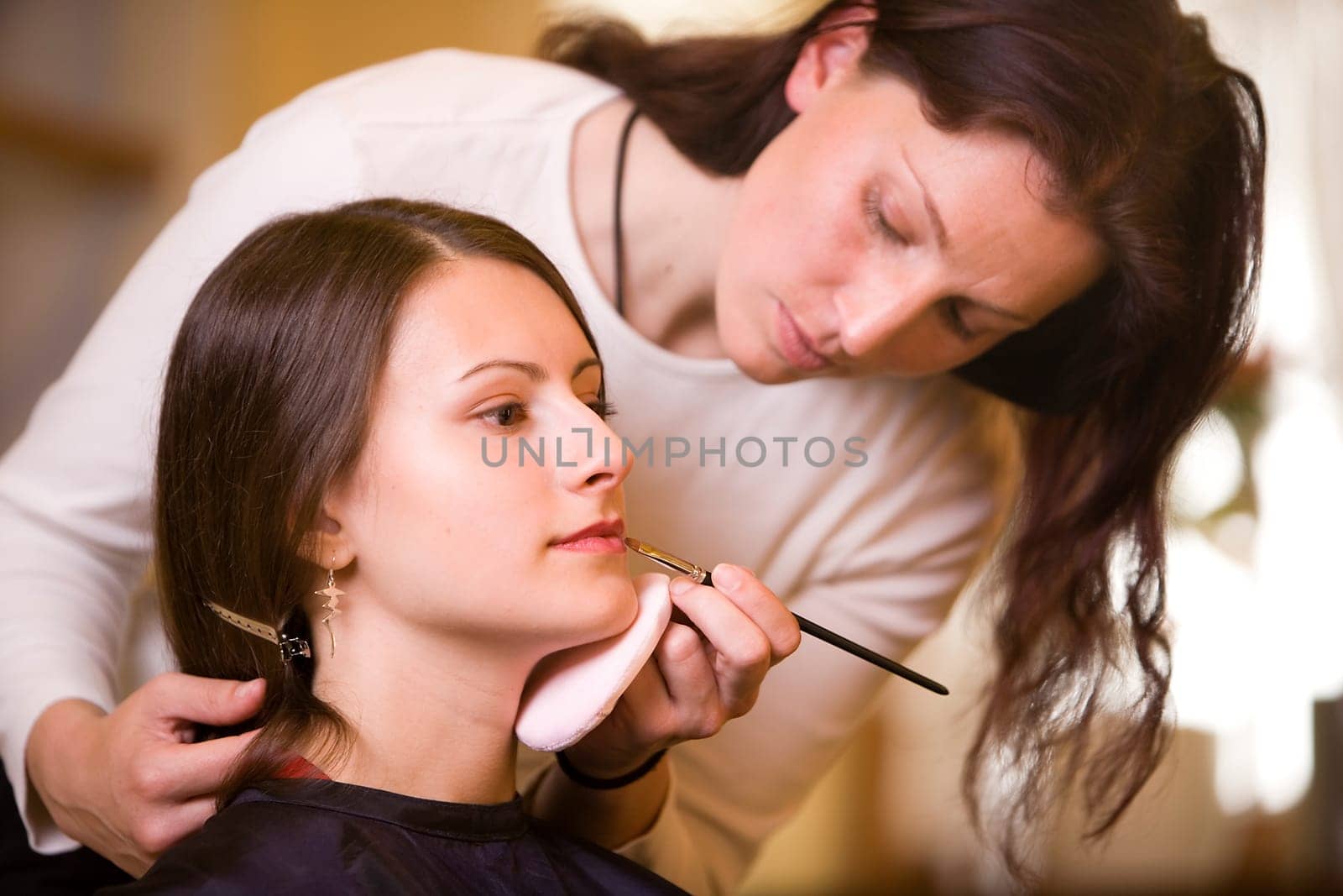 Woman doing make-up with make-up artist