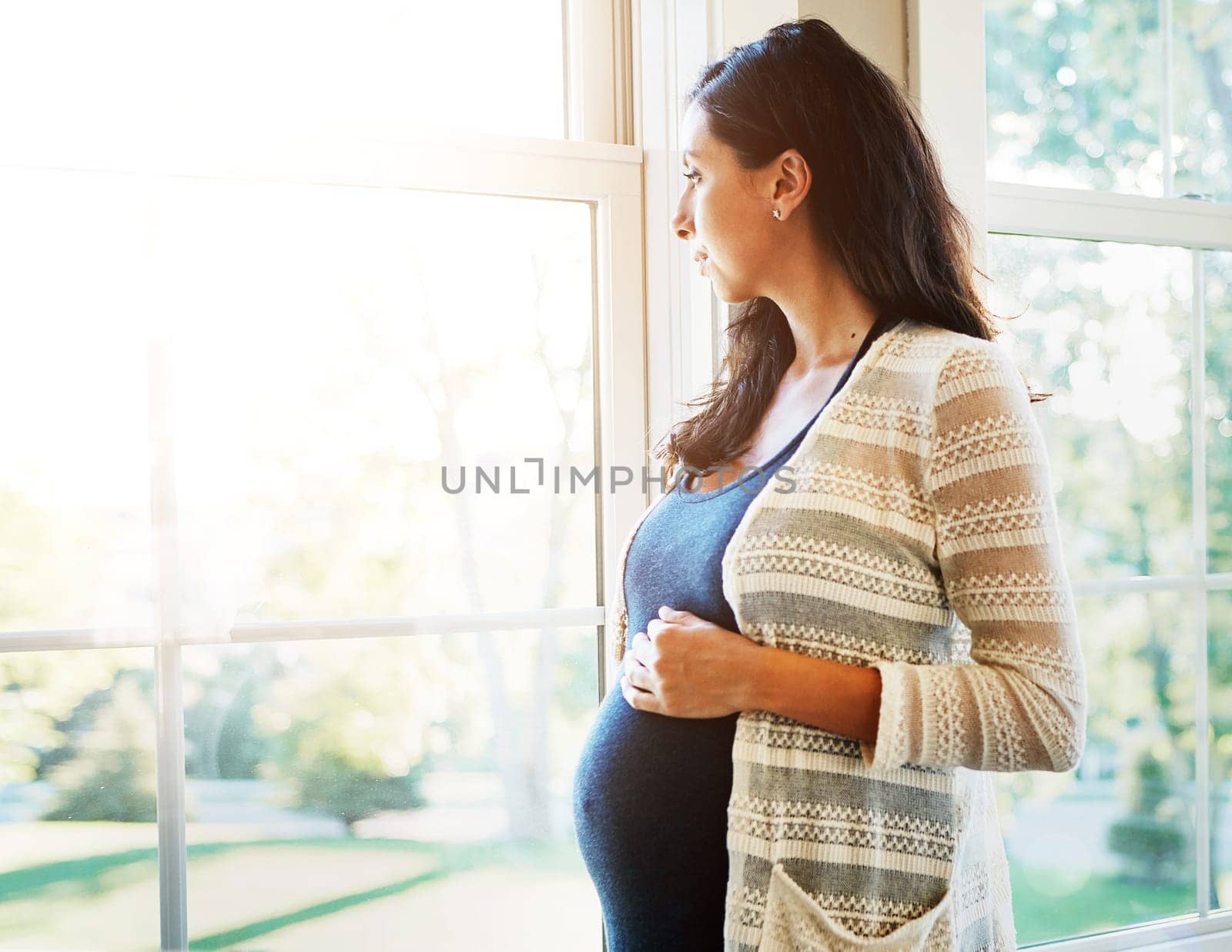 Woman, pregnant and thinking on future at window, hope and maternity, love and hands on stomach. Mother, healthy and care for baby, prenatal wellness and support in motherhood, home and family by YuriArcurs