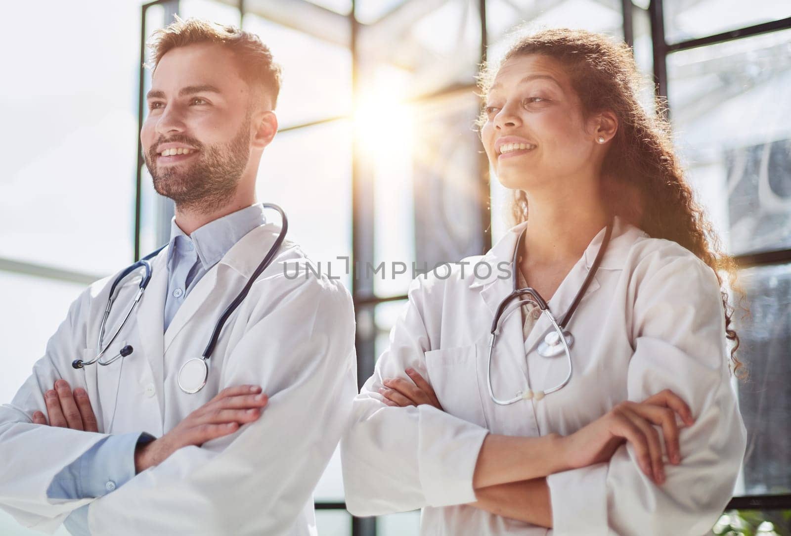 Young male and female dentists look into the distance in a hospital room