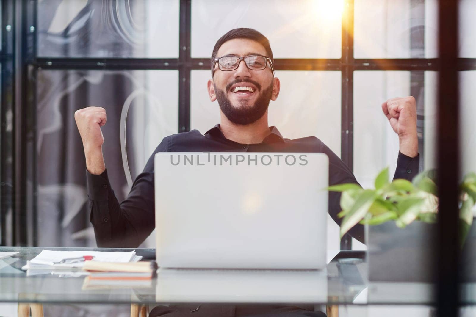 Business man sitting at his desk in the office with a laptop