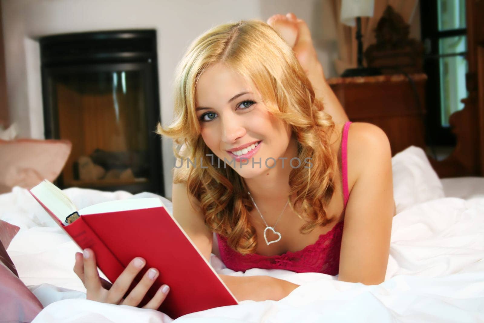 Woman with book in bed