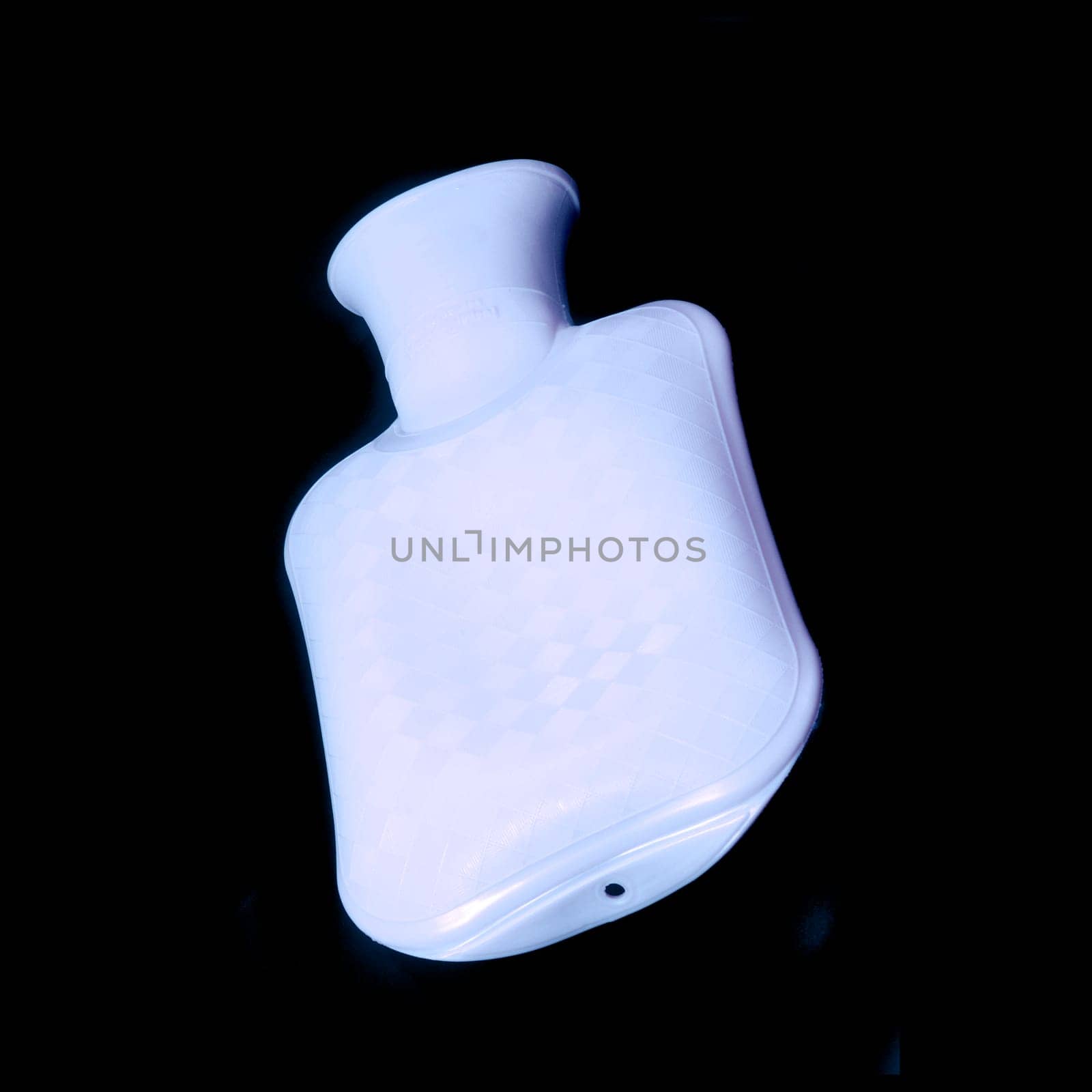 Blue hot water bottle in front of black