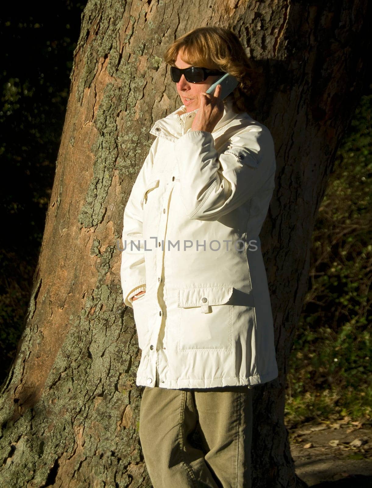Woman talking on the phone in autumn sun