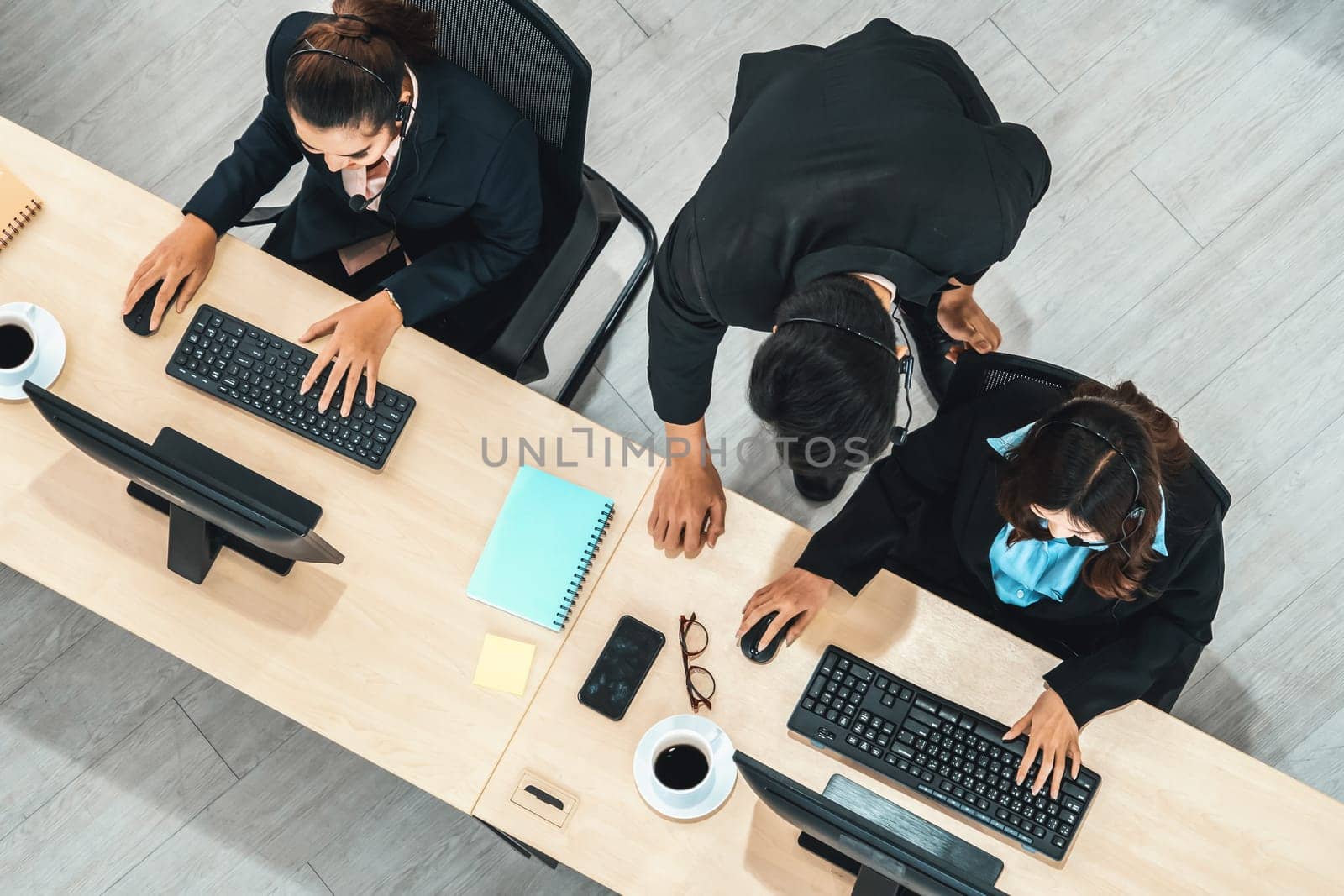 Business people wearing headset shot from top view in office working with computer. Jivy